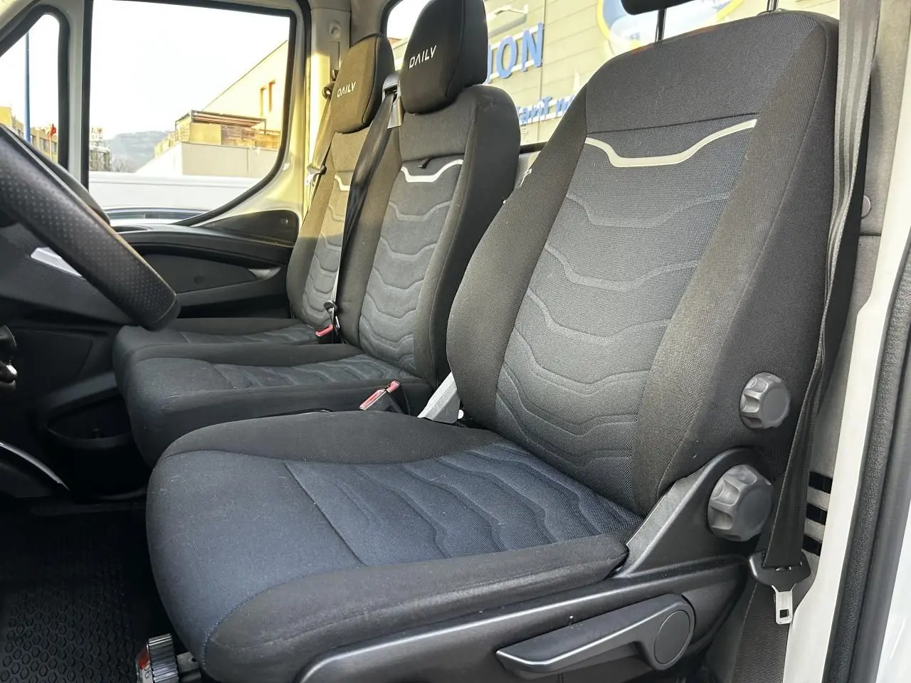 Vue intérieure côté droit montrant les sièges noirs du IVECO Daily6 35 S16 2.3 D de 2020 avec appuie-têtes brodés Daily.