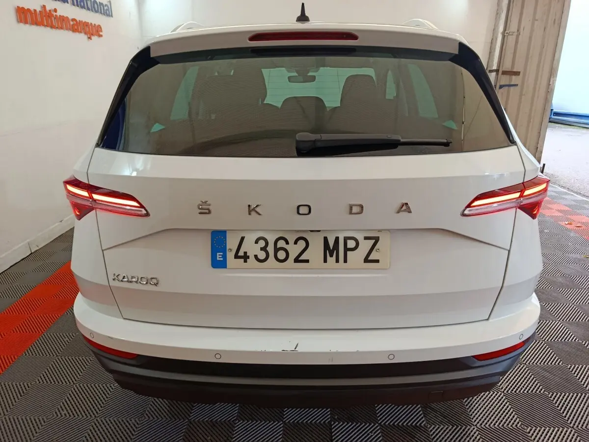 Vue arrière d'un Skoda Karoq blanc 2024 avec feux LED allumés et plaque d'immatriculation espagnole visible