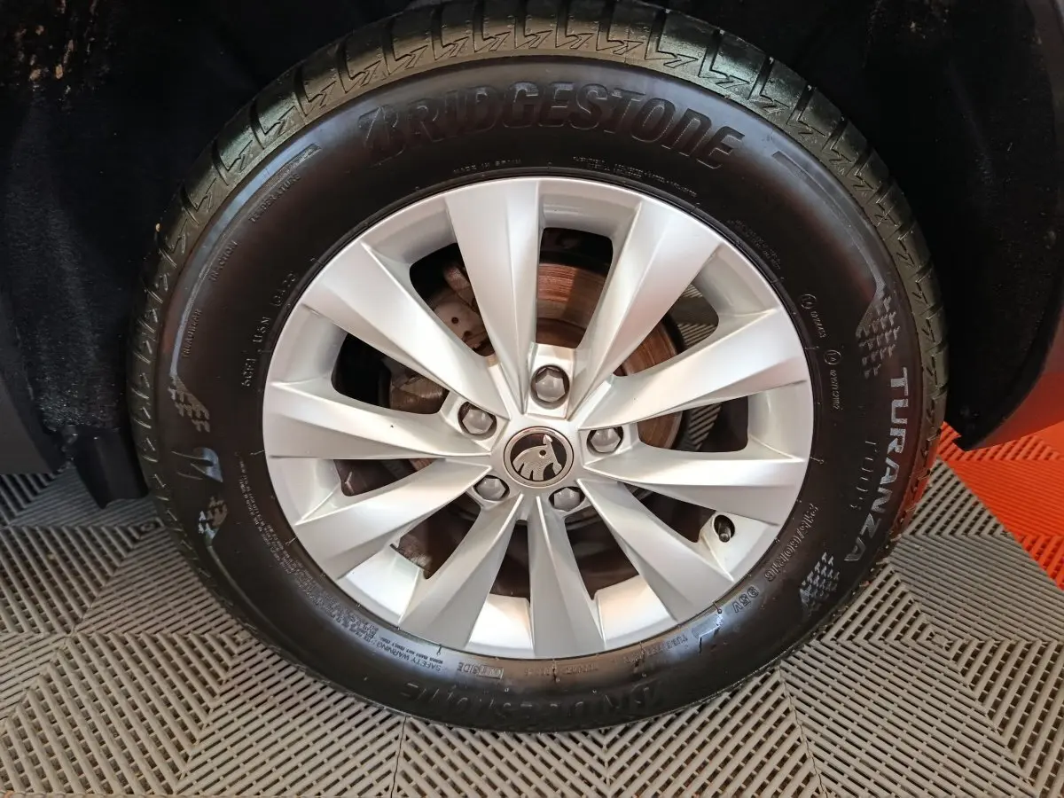 Gros plan sur la roue avant droite du Skoda Karoq blanc, jante alliage à 10 branches et pneu Bridgestone Turanza.