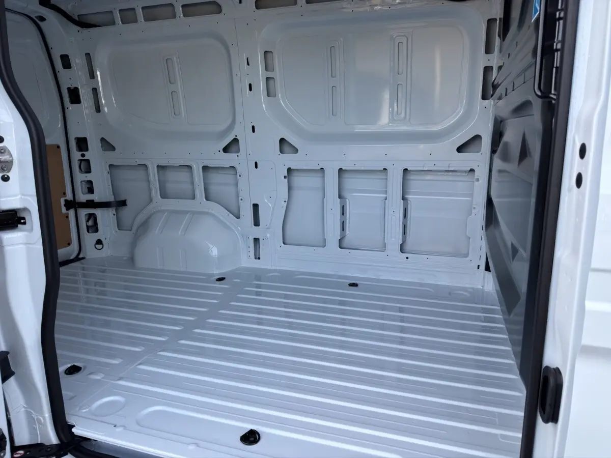 Vue intérieure arrière du fourgon blanc Renault Master FG L2H2, montrant l'espace de chargement vide et la cloison pleine.