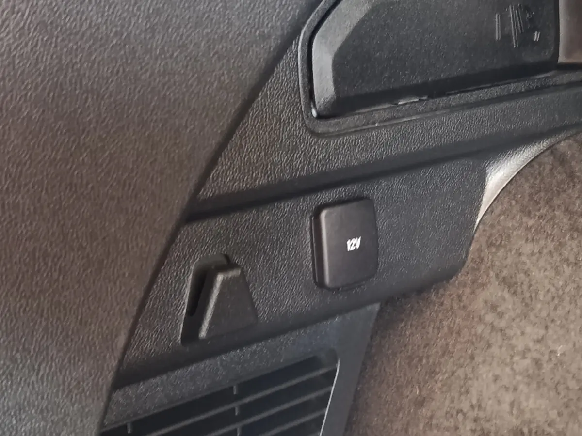 Gros plan sur prise 12V et crochet d’arrimage dans le coffre du Ford Kuga gris foncé 2023.