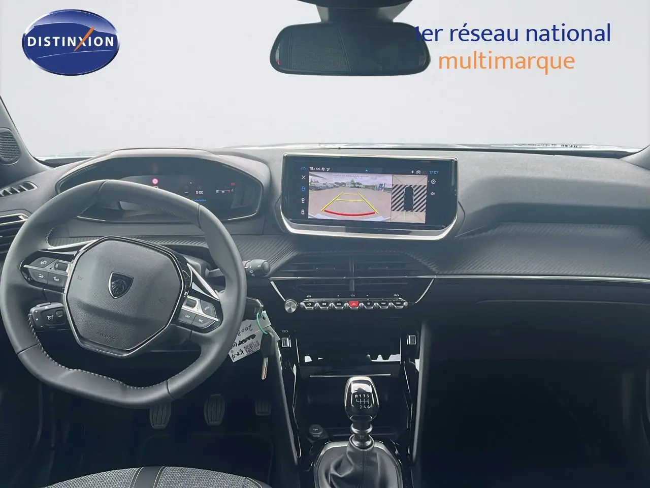 Vue intérieure avant du Peugeot 2008 blanc, mettant en valeur le tableau de bord numérique et l'écran tactile avec caméra de recul.