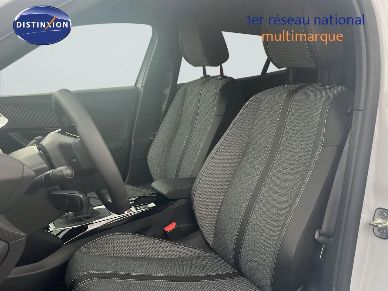 Intérieur du Peugeot 2008 2025 blanc Okenite, vue côté gauche sur sièges tissu gris à motifs et volant.