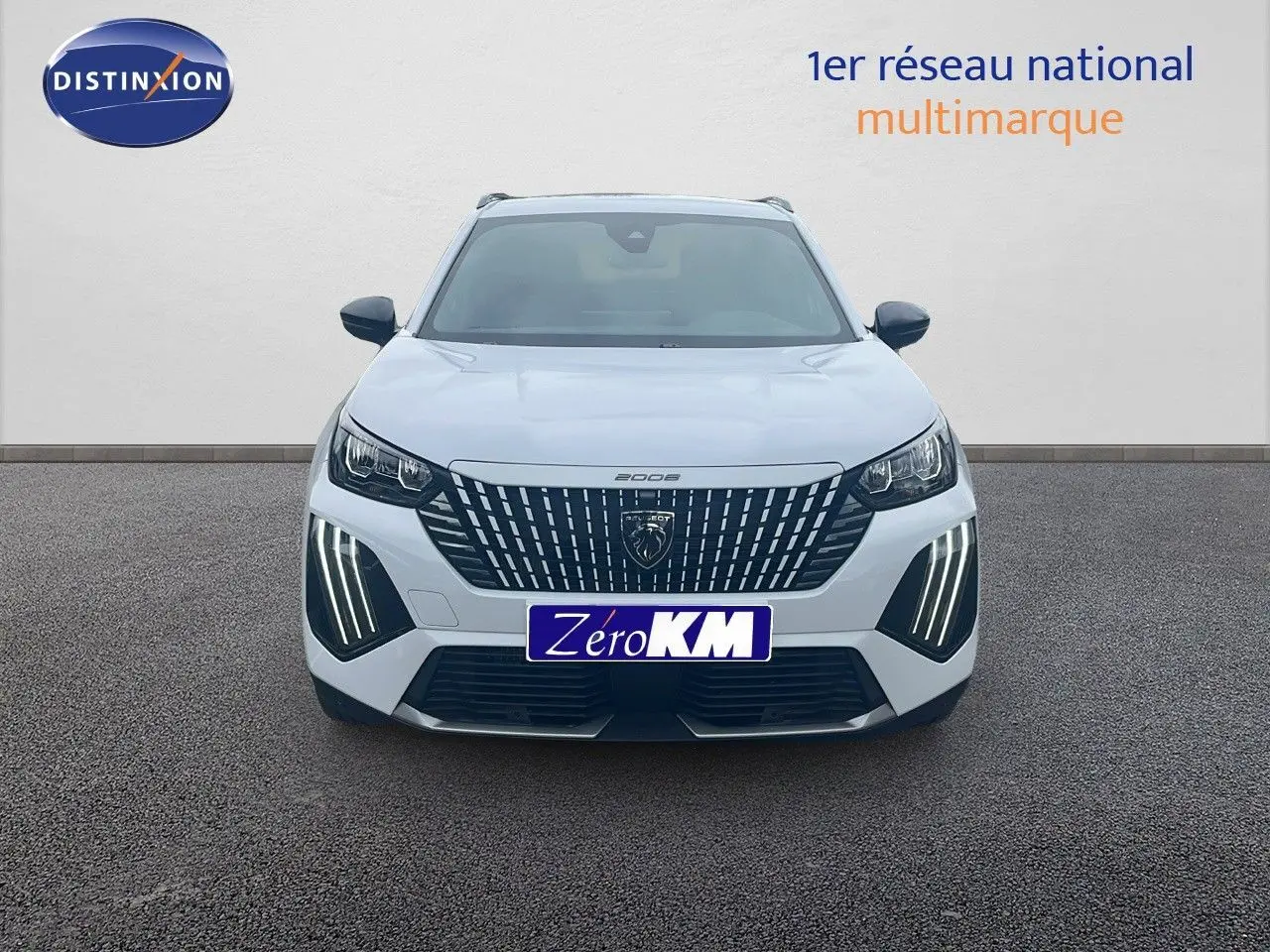 Vue frontale d'un Peugeot 2008 blanc Okenite Metal avec feux LED verticaux allumés sur un sol gris.