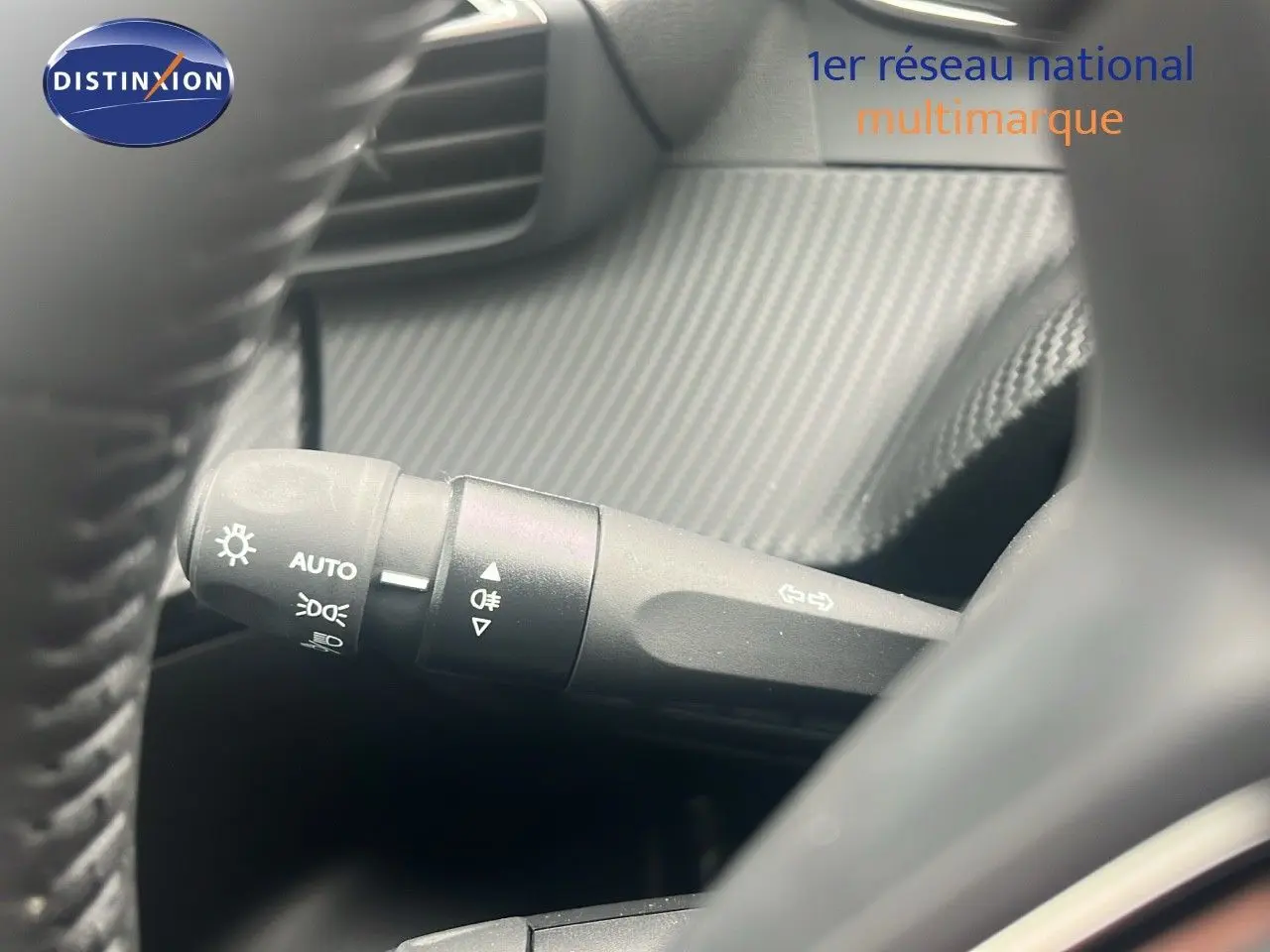 Gros plan sur la commande des feux et clignotants du Peugeot 2008 blanc, visible depuis le volant côté gauche.