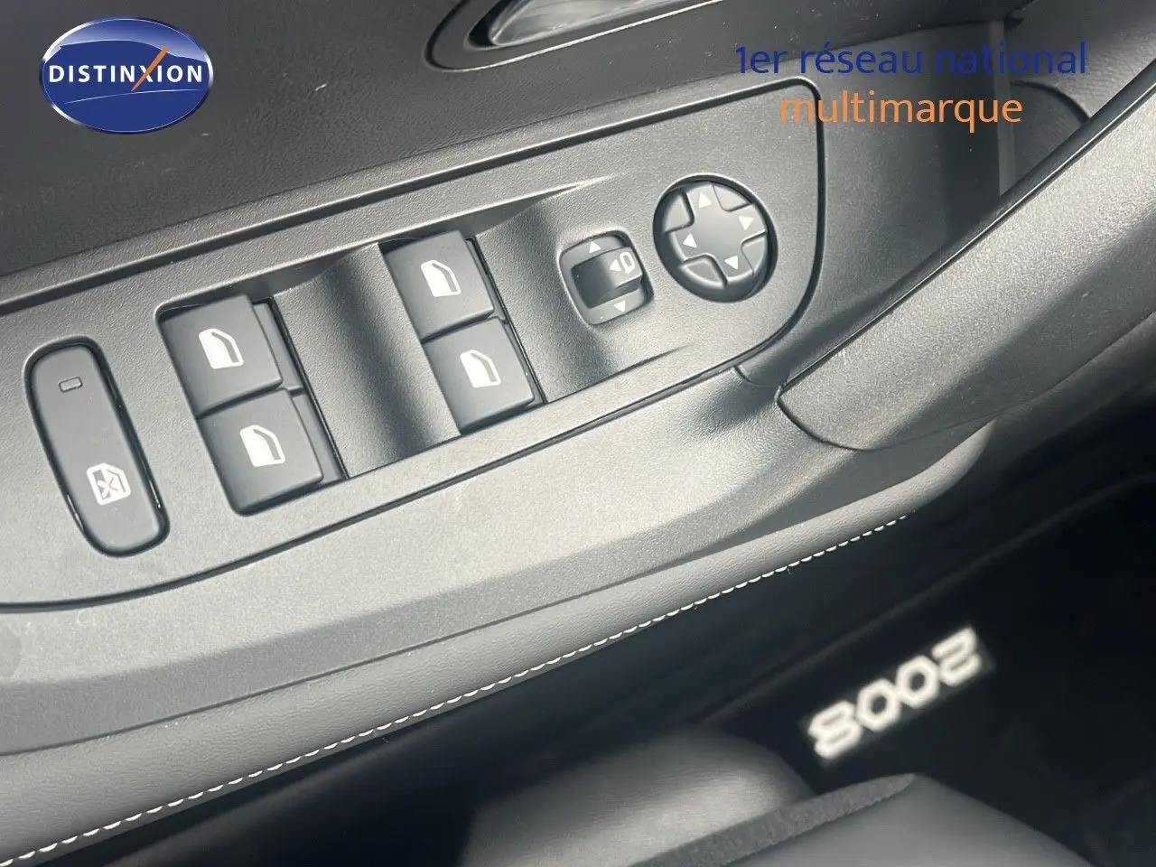 Gros plan sur les commandes de lève-vitres et rétroviseurs côté conducteur d'un Peugeot 2008 2025 intérieur noir.