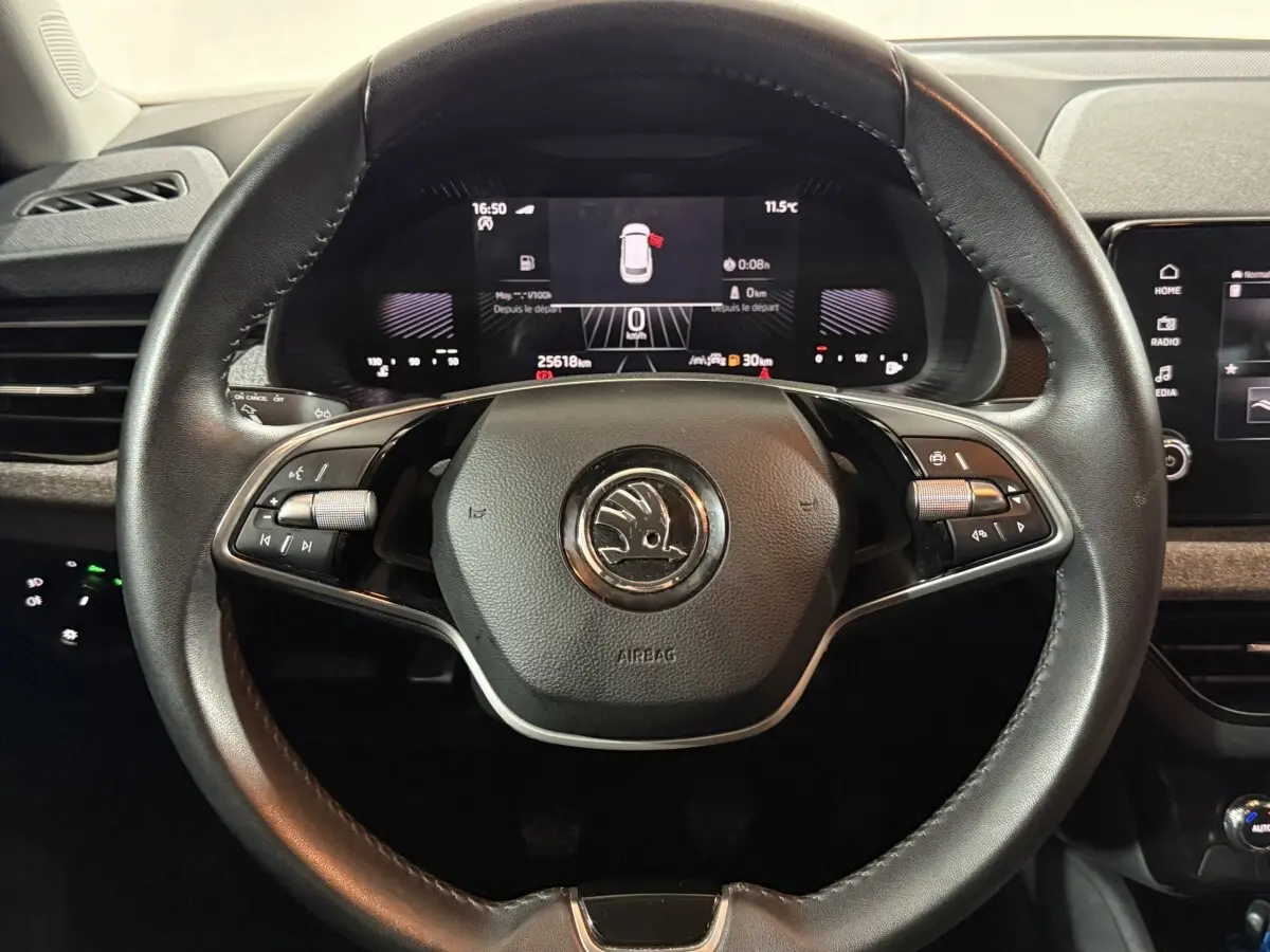 Volant cuir noir SKODA KAMIQ 2024 avec commandes multifonctions et tableau de bord numérique en arrière-plan