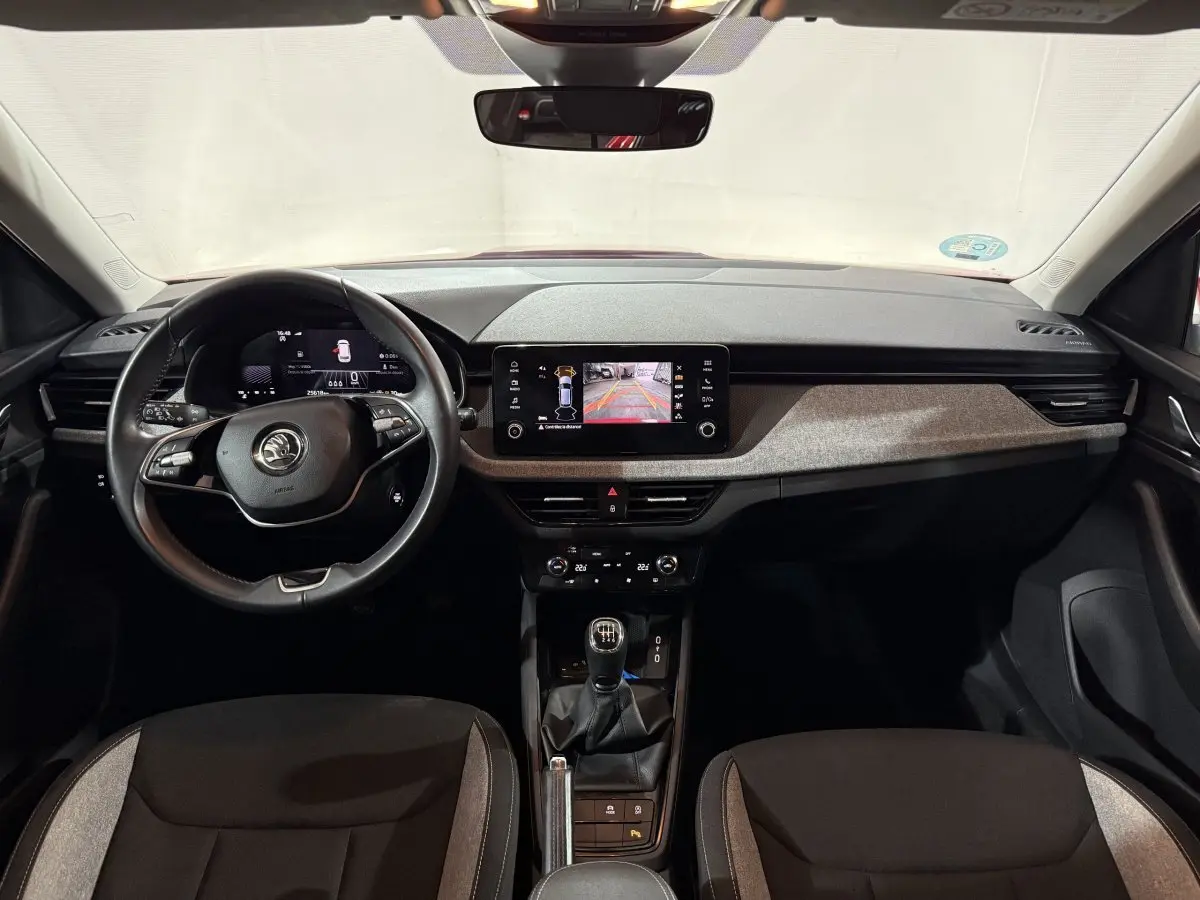Intérieur de la Skoda Kamiq 2024, vue frontale du tableau de bord avec volant cuir et écran tactile central.