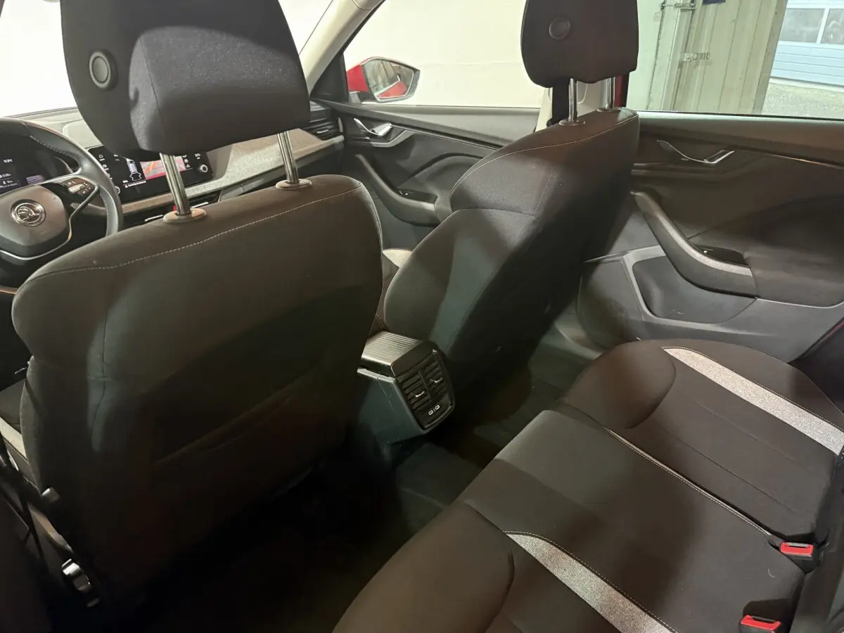 Vue intérieure arrière du Skoda Kamiq 2024 avec sièges noirs et console centrale équipée de prises USB.
