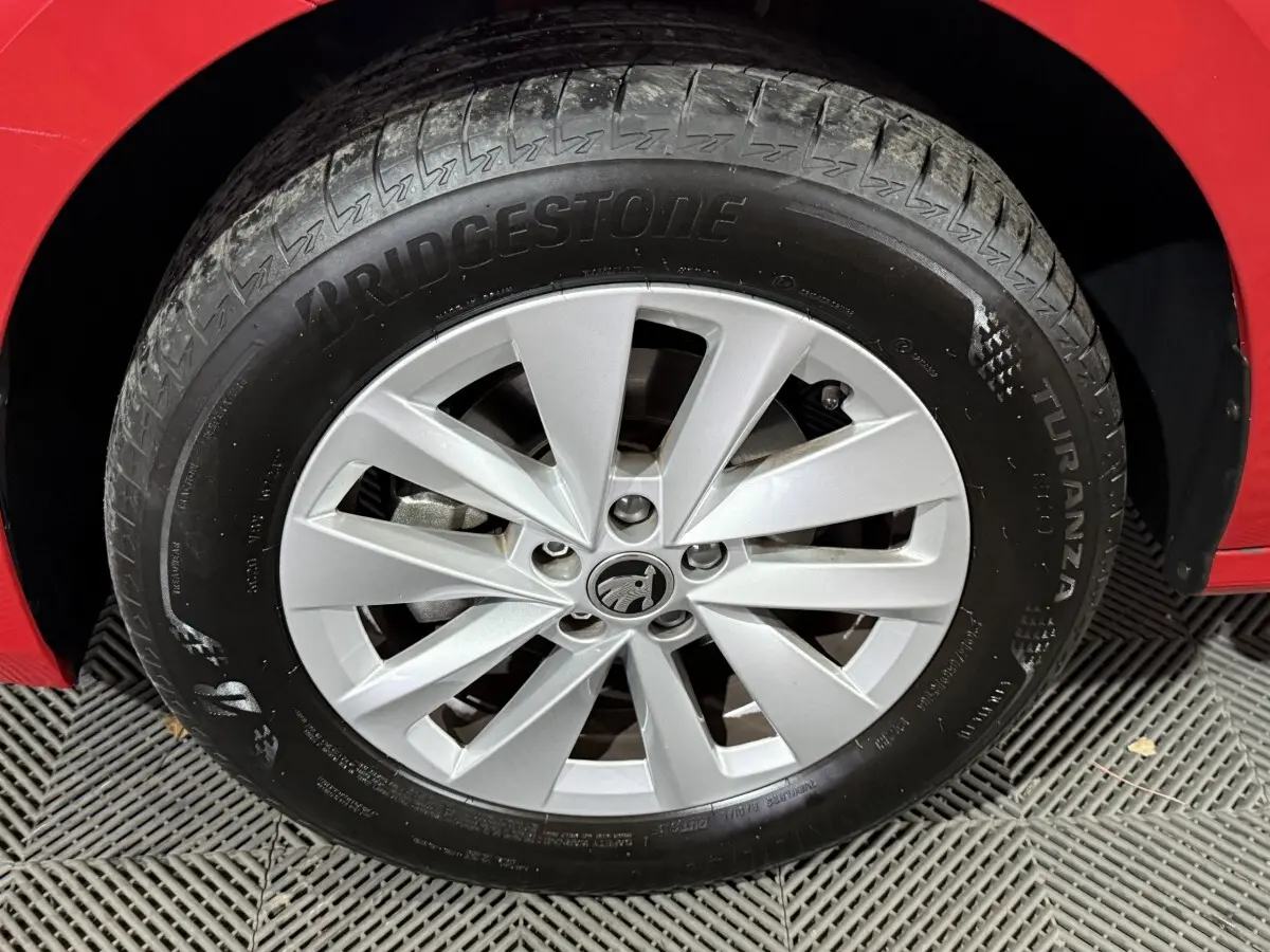 Gros plan sur la roue avant droite du Skoda Kamiq rouge 2024, mettant en valeur la jante argentée et le pneu Bridgestone.