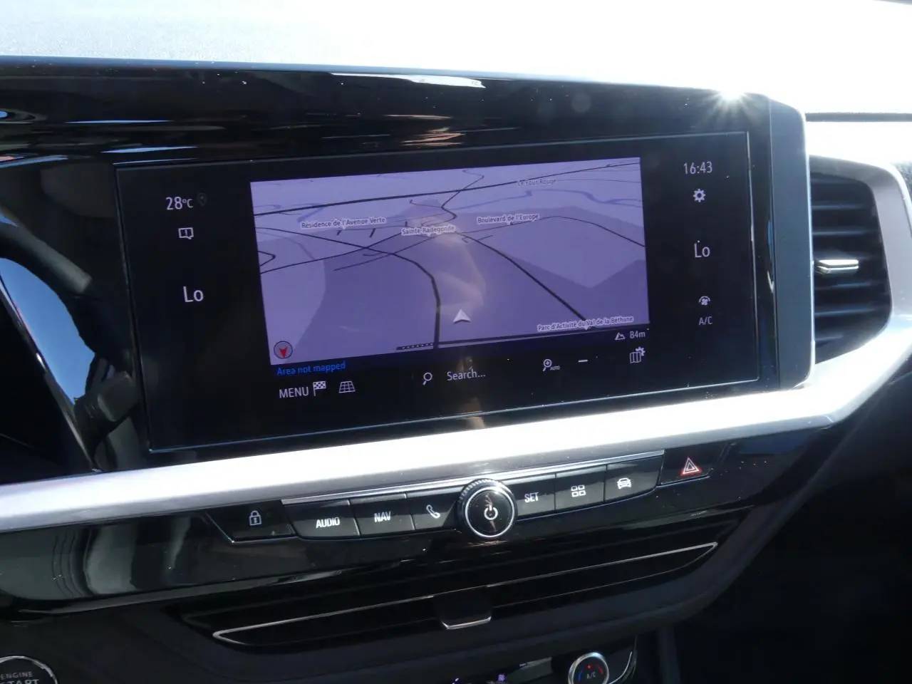 Écran tactile central du tableau de bord de l’Opel Grandland blanc, affichant la navigation GPS en plein jour.