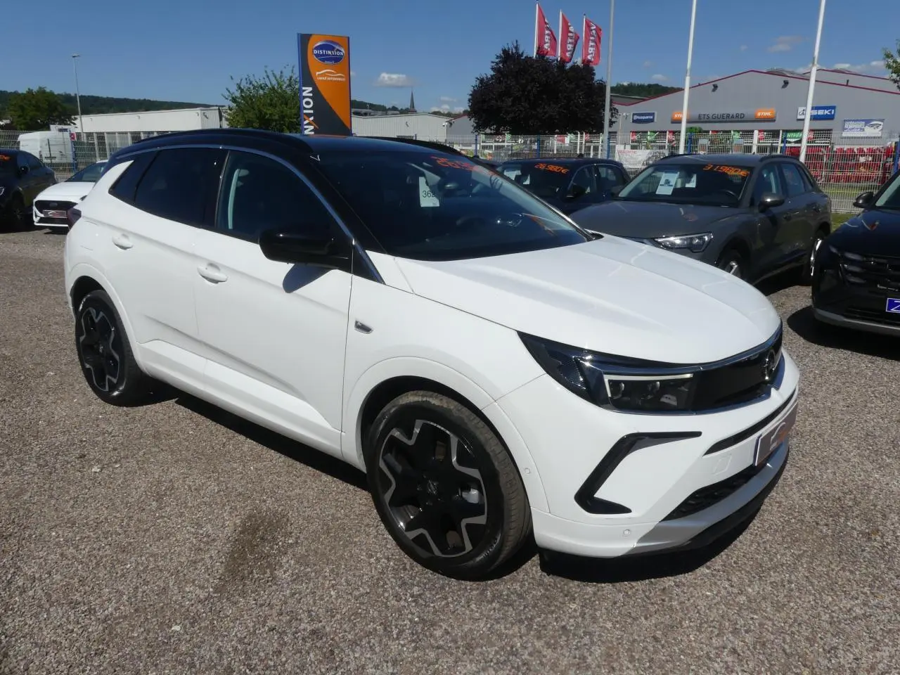 Opel Grandland blanc métallisé en 3/4 avant droit avec toit noir et jantes alliage noires.