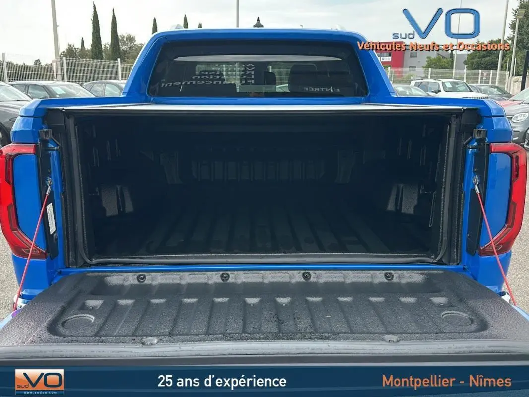 Vue arrière du coffre ouvert du pick-up Volkswagen Amarok Simple Cabine bleu, montrant la benne spacieuse et protégée.