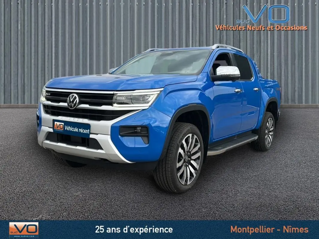 Vue 3/4 avant droite d'un Volkswagen Amarok Simple Cabine bleu avec jantes alliage 21 pouces et marchepieds noirs.