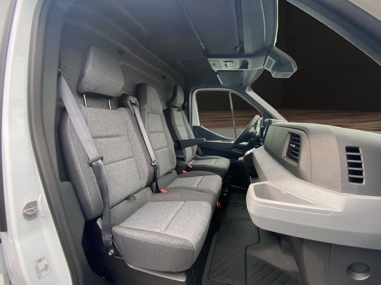 Vue intérieure côté gauche du Renault Master blanc 2025, montrant la banquette passager grise et le tableau de bord clair.