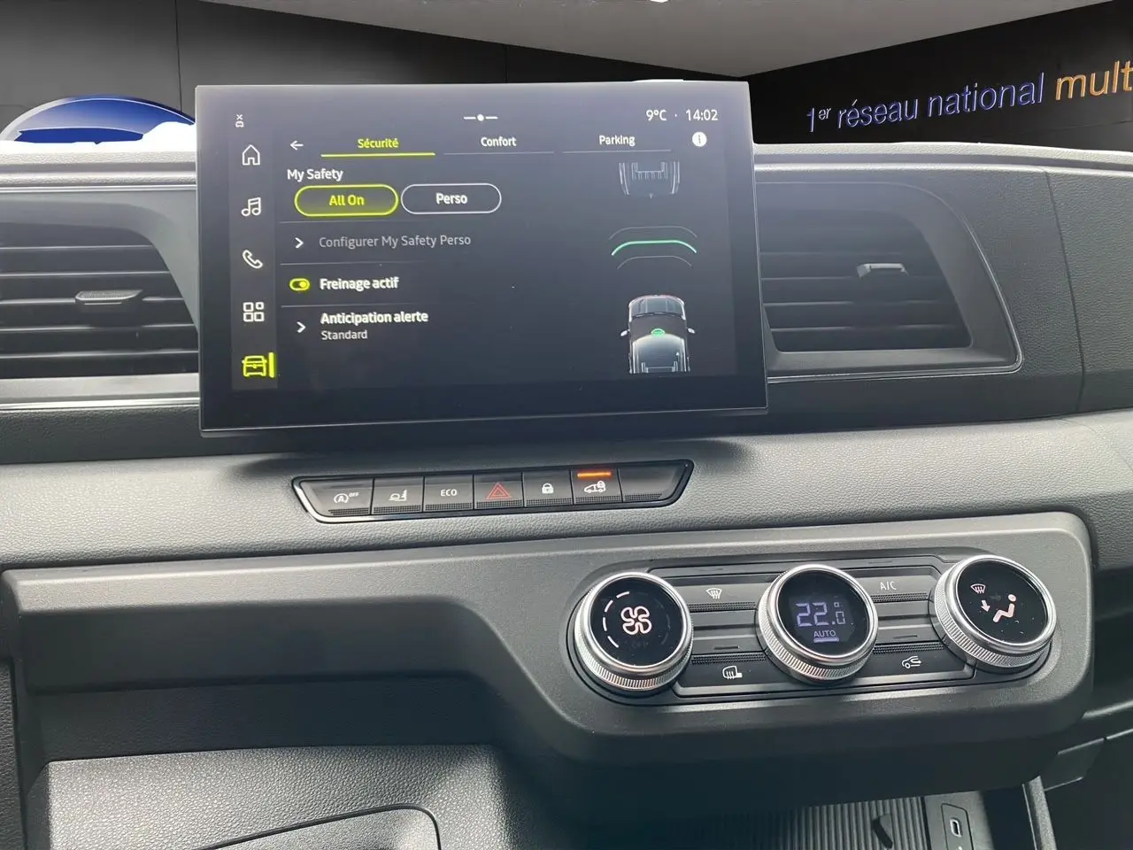 Vue rapprochée du tableau de bord du Renault Master blanc 2025, mettant en valeur l'écran tactile et les commandes de climatisation.