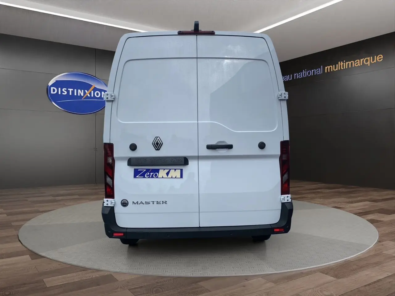 Vue arrière d’un Renault Master blanc avec portes arrière tôlées et logo noir sur fond clair en showroom.