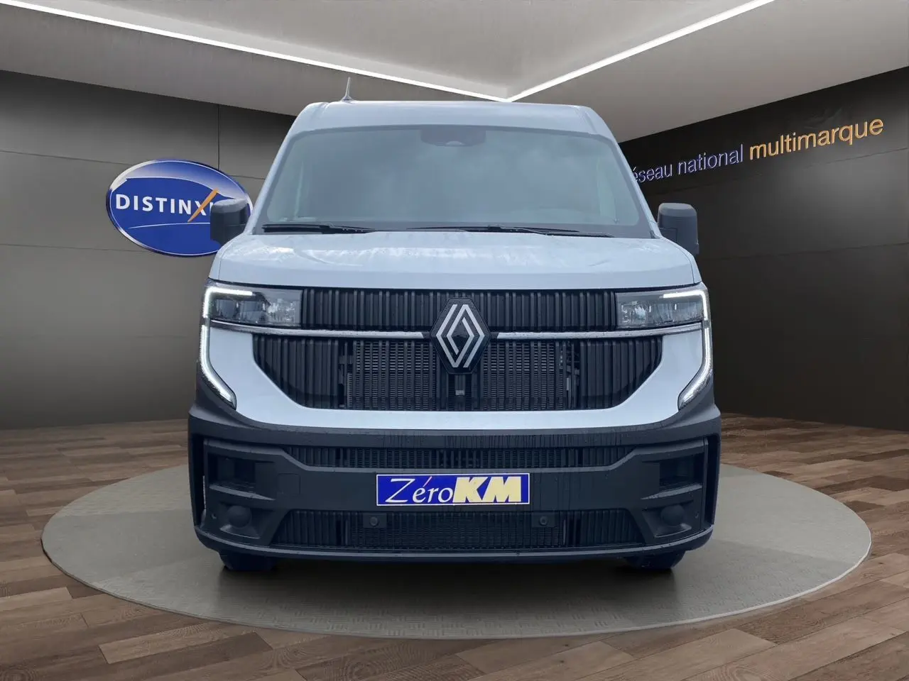 Vue frontale d'un Renault Master blanc avec calandre noire et éclairage LED en forme de C.