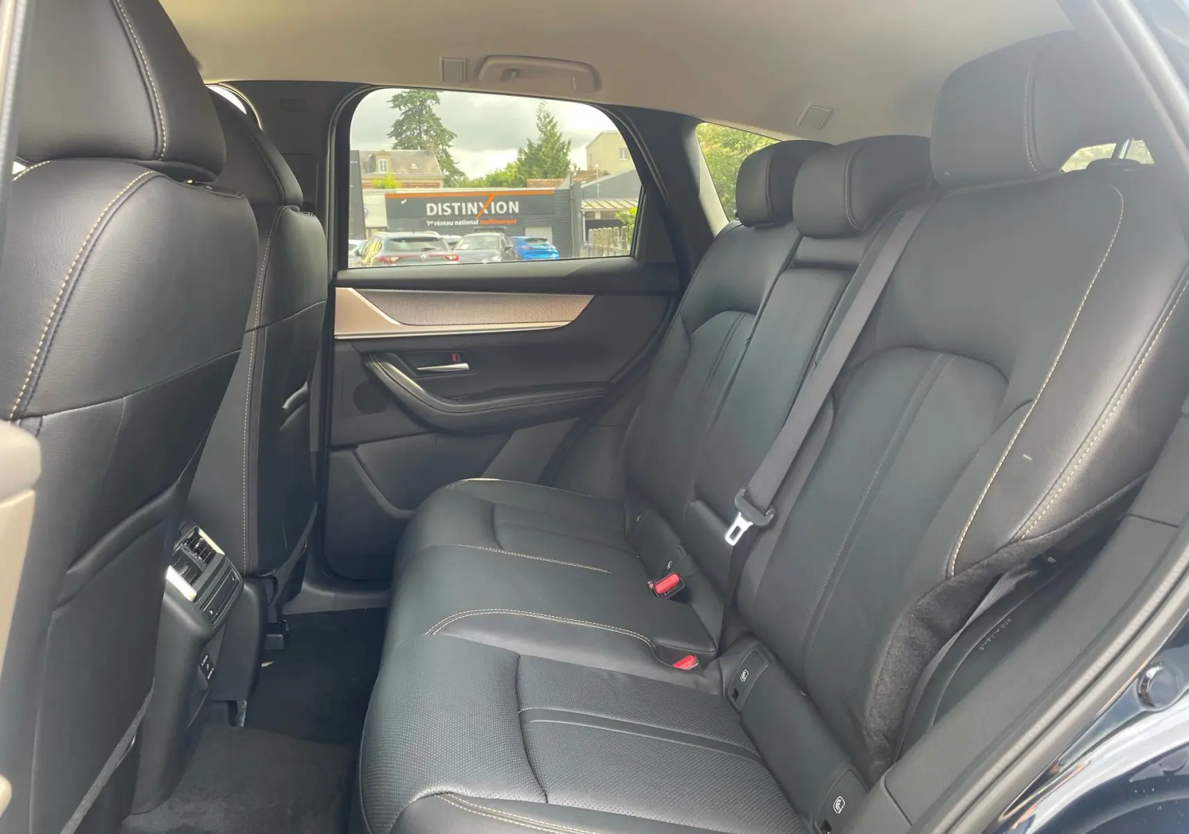 Vue intérieure sur la banquette arrière en cuir noir du Mazda CX-60 2024, côté droit, avec porte ouverte et finition soignée.