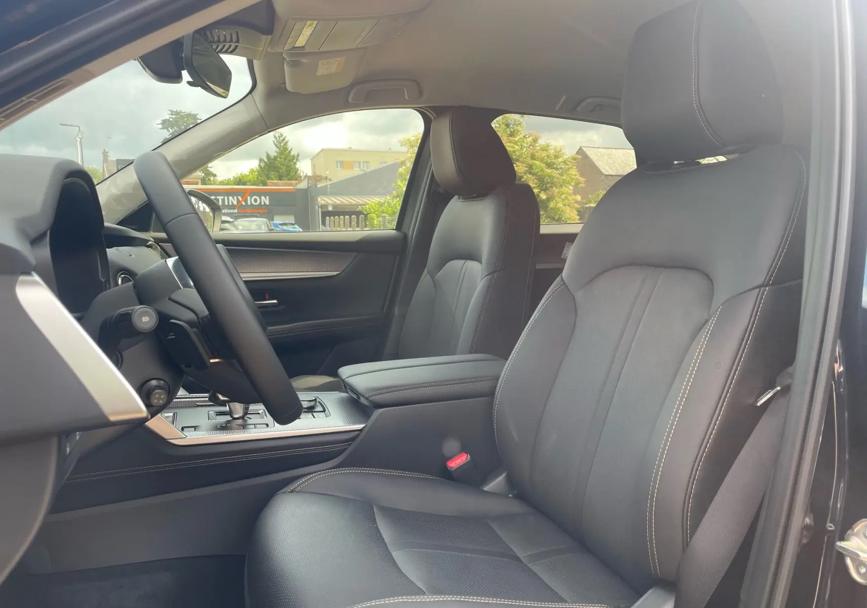 Vue intérieure côté conducteur du Mazda CX-60 2024 avec sièges en cuir noir et console centrale moderne.