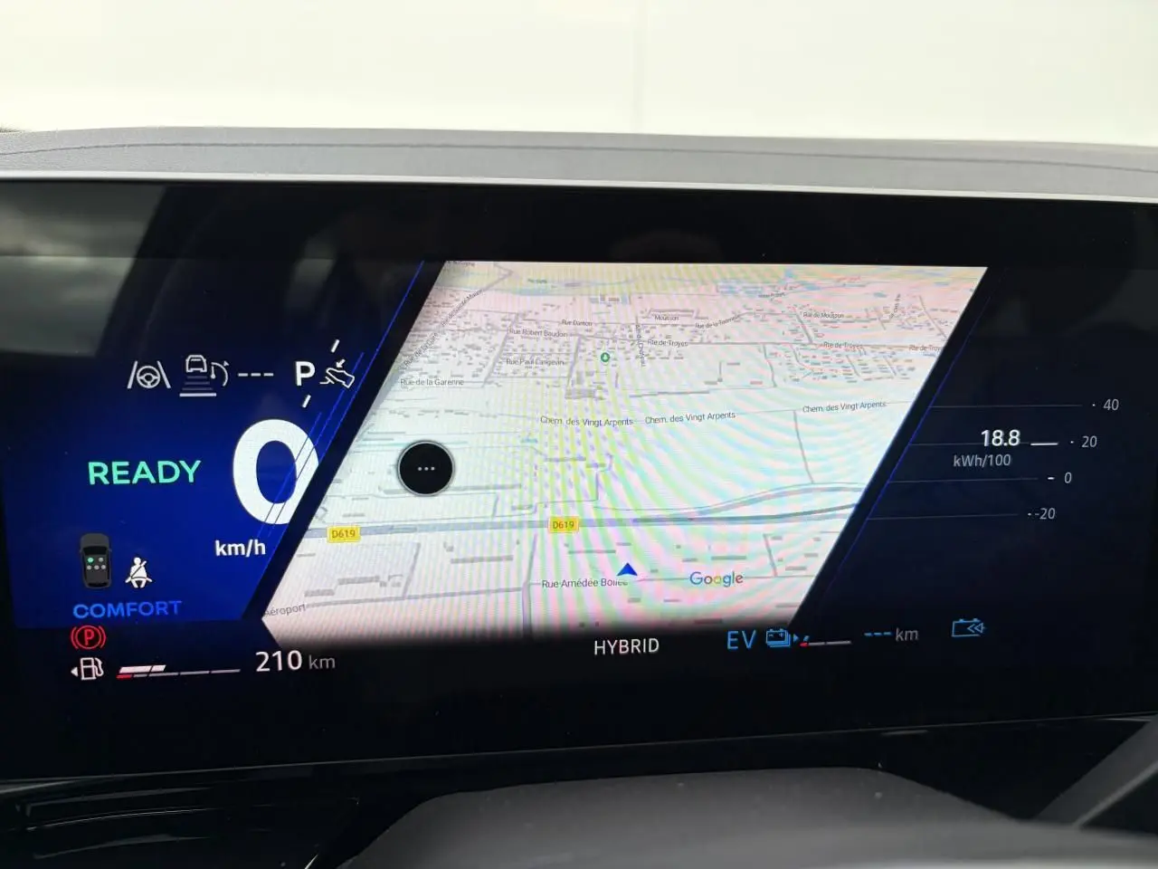 Affichage numérique du tableau de bord Renault Rafale 2025 avec navigation Google Maps et indicateurs hybrides.