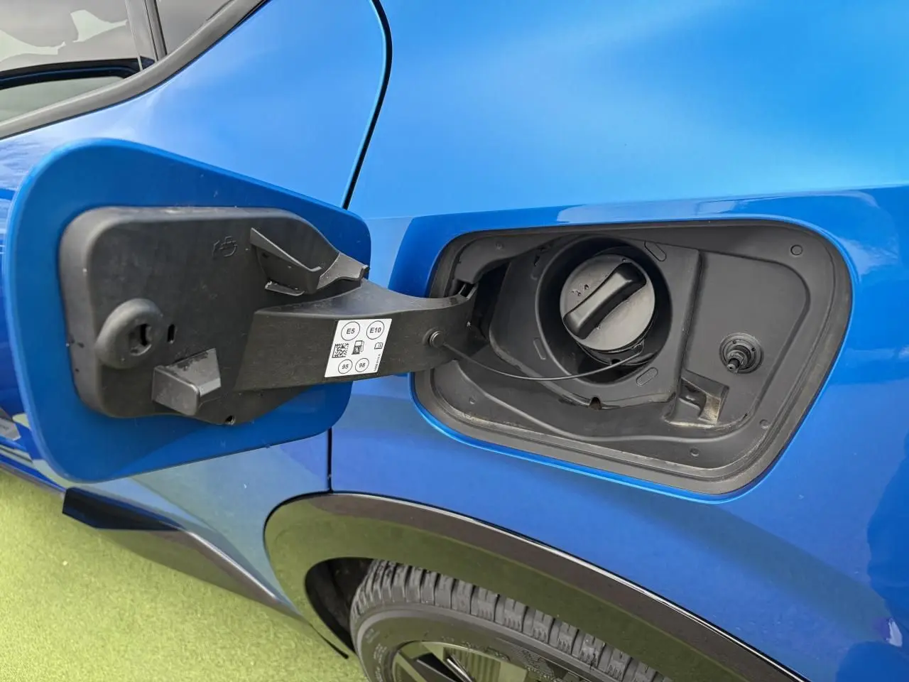 Détail de la trappe de carburant ouverte côté gauche sur Renault Rafale Summit Blue 2025 hybride rechargeable.
