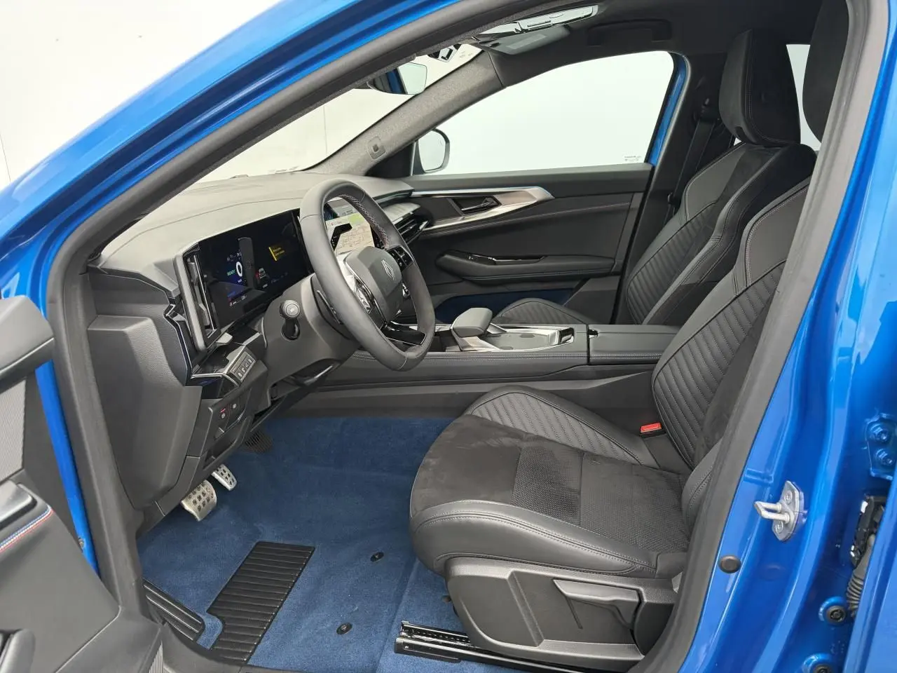 Vue intérieure côté conducteur de la Renault Rafale Summit Blue 2025, sièges sport noirs et volant Alcantara.
