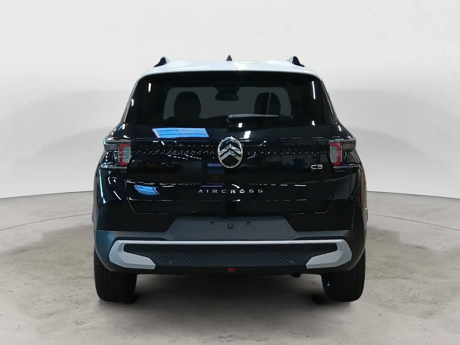 Vue arrière du Citroën C3 Aircross 2025 noir perla avec toit blanc, mettant en valeur son logo et ses feux distinctifs.