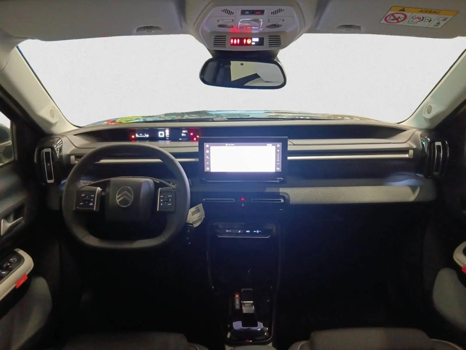Intérieur du Citroën C3 Aircross 2025 vu de face, tableau de bord moderne avec écran tactile central et volant multifonction.