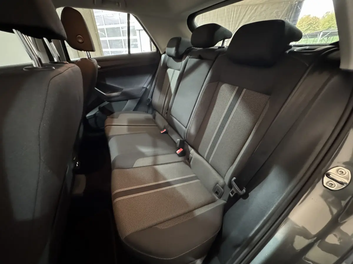 Vue intérieure côté droit des sièges arrière en tissu gris avec surpiqûres, dans un Volkswagen T-Roc gris foncé 2021.