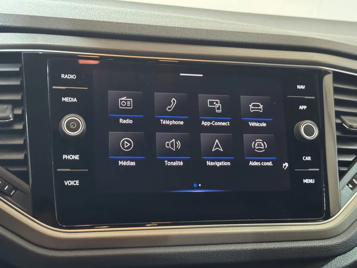 Écran tactile central du Volkswagen T-Roc 2.0 TDI gris foncé, affichant les options multimédia et navigation.