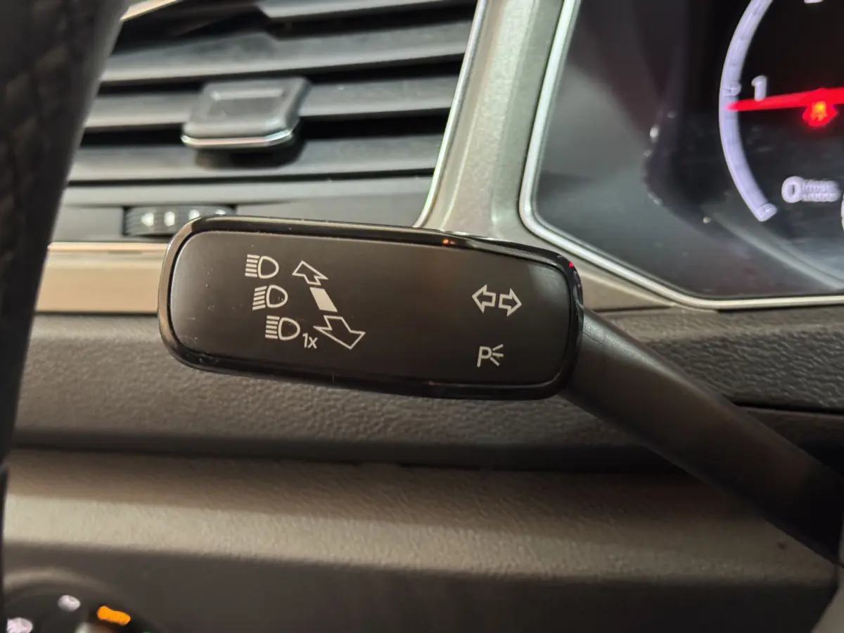 Gros plan sur la commande de clignotants et feux du Volkswagen T-Roc 2021, intérieur gris foncé.