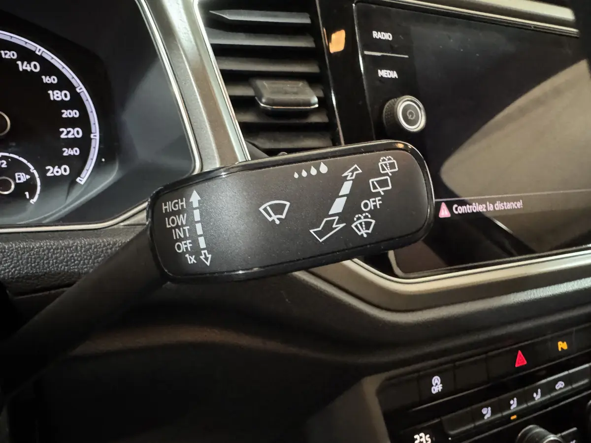 Gros plan sur la commande d’essuie-glace du Volkswagen T-Roc 2.0 TDI 115 Lounge Business, tableau de bord noir visible.