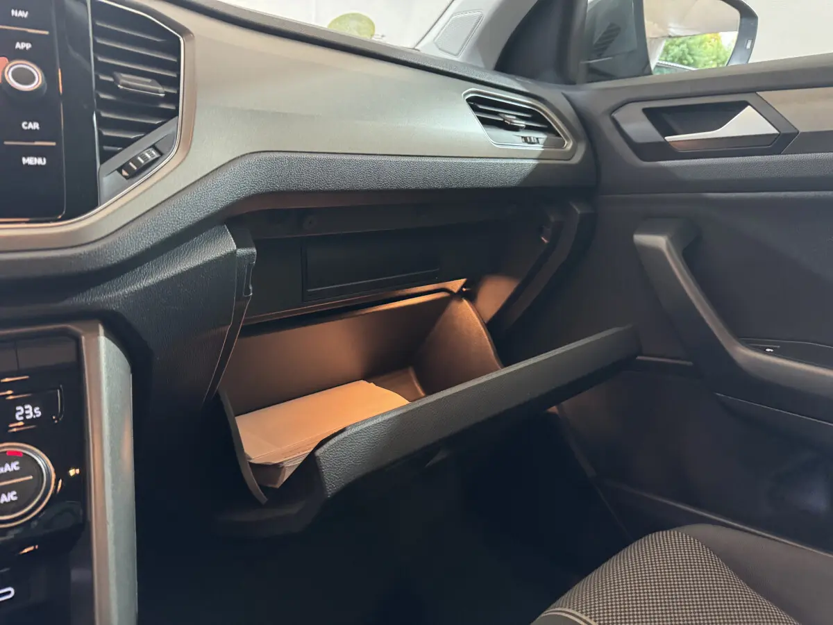 Vue intérieure côté passager du Volkswagen T-Roc 2.0 TDI 115 Lounge Business 2021, boîte manuelle, avec boîte à gants ouverte et éclairage intérieur.