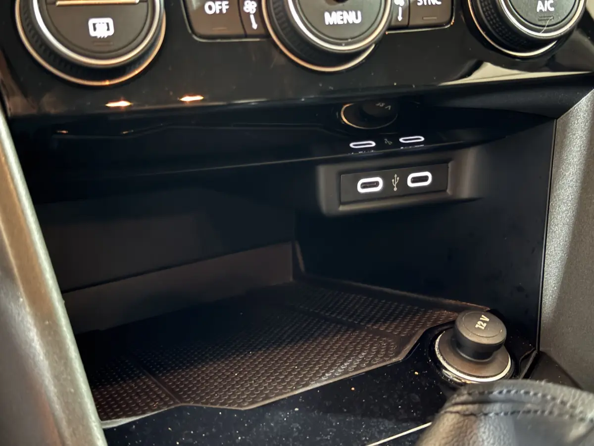 Prise USB double et prise 12V dans la console centrale du Volkswagen T-Roc gris foncé, vue rapprochée intérieure.