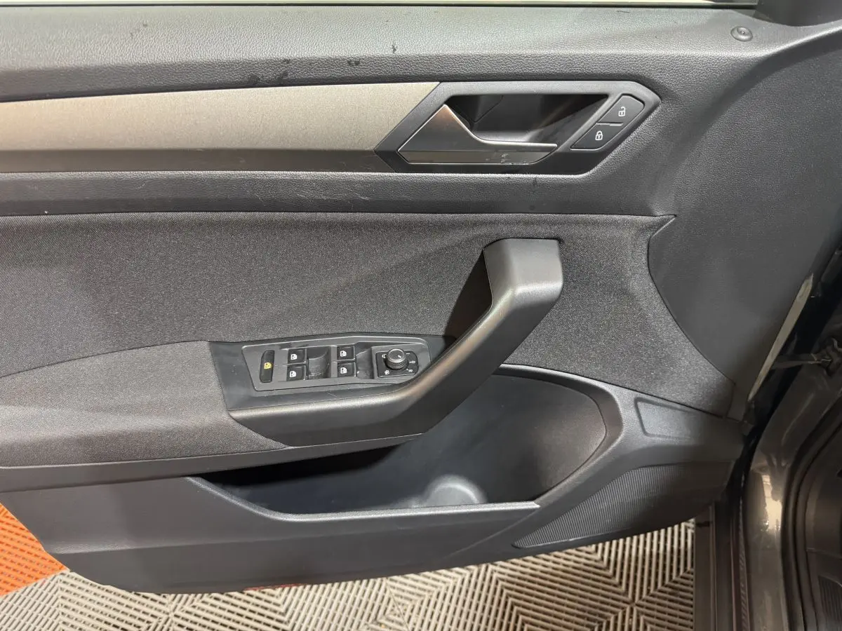 Vue intérieure côté gauche de la porte d’un Volkswagen T-Roc gris foncé avec commandes de vitres et verrouillage.
