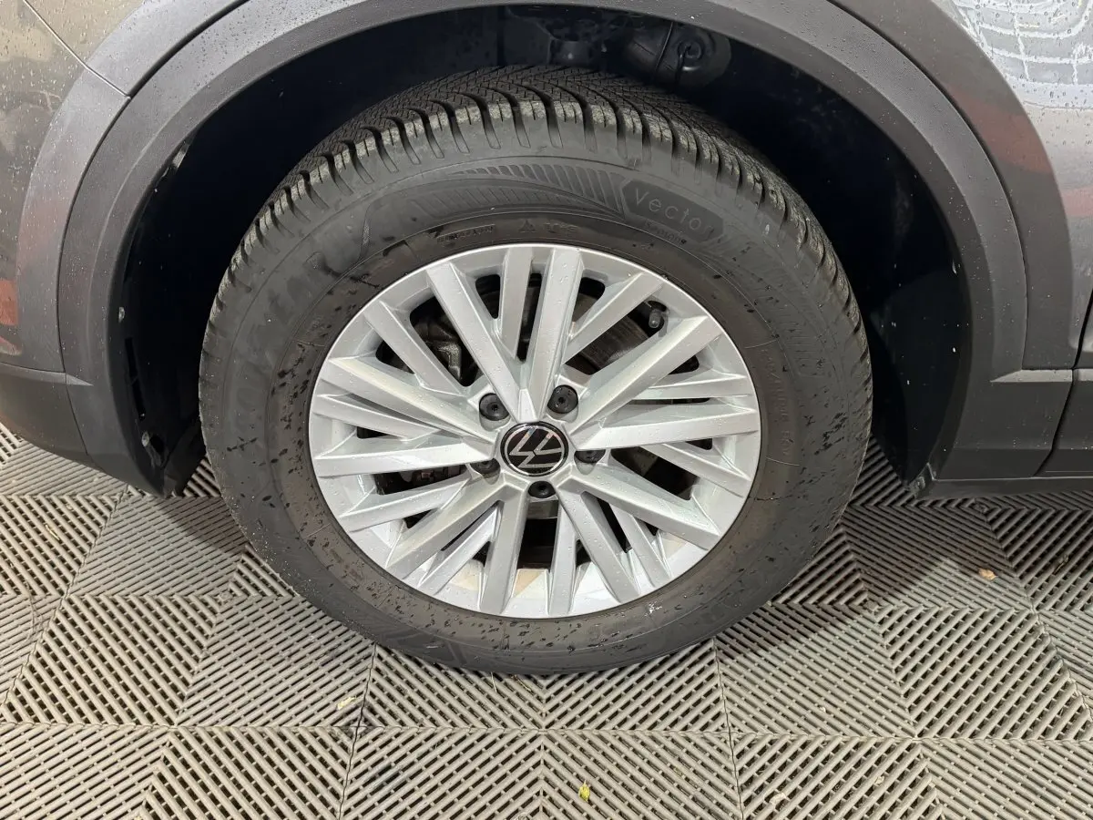 Gros plan sur la roue avant gauche grise du Volkswagen T-Roc 2.0 TDI 115 Lounge Business avec jante en alliage argentée.