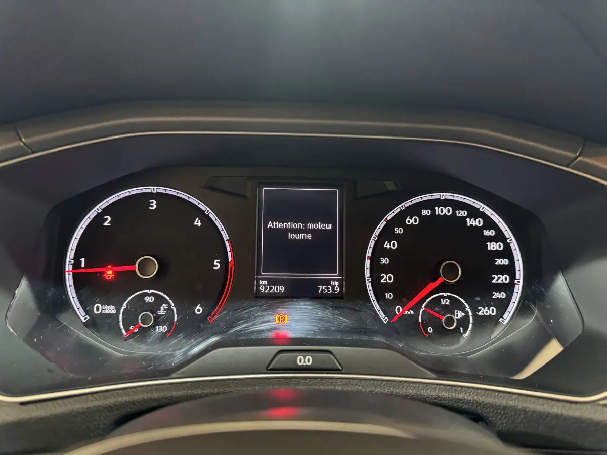 Tableau de bord du Volkswagen T-Roc gris foncé 2021, affichage digital avec message d'alerte moteur et compteurs analogiques.
