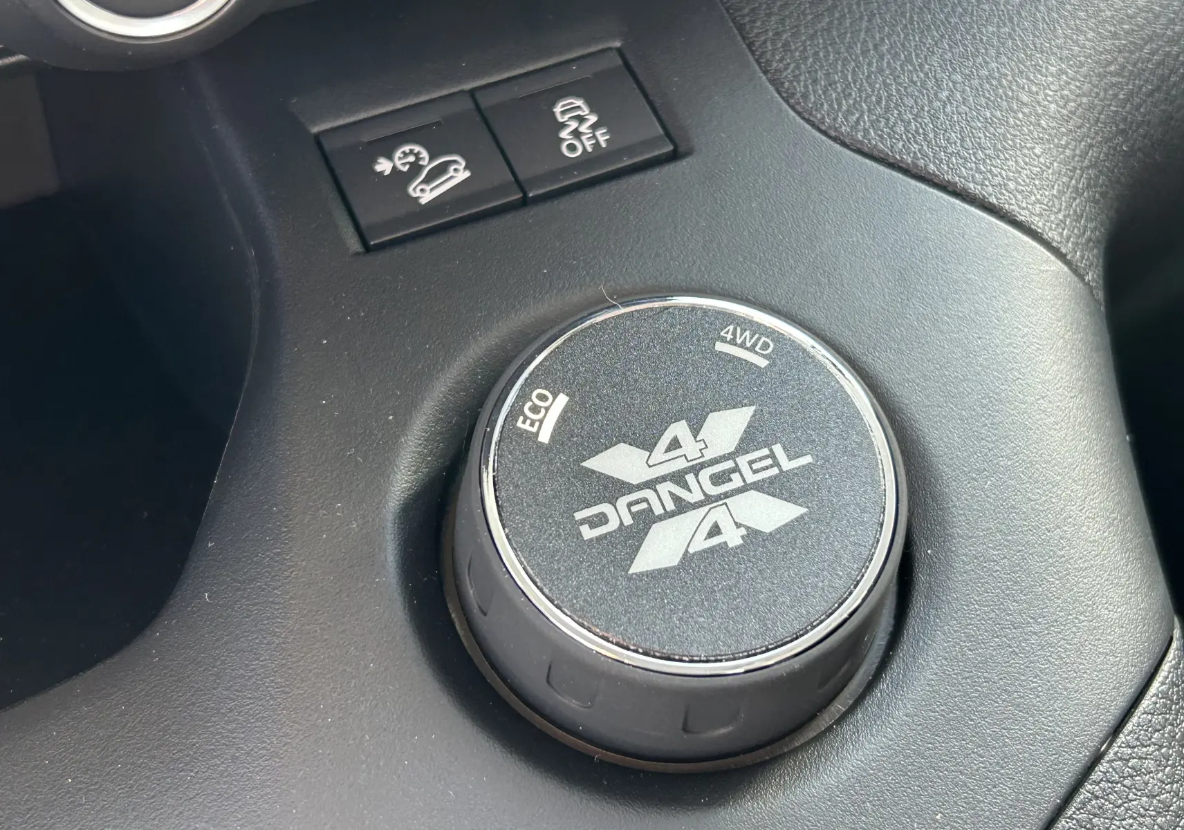 Gros plan sur le sélecteur rotatif Dangel 4x4 dans l’habitacle du Peugeot Partner gris Artense, vue intérieure côté console.