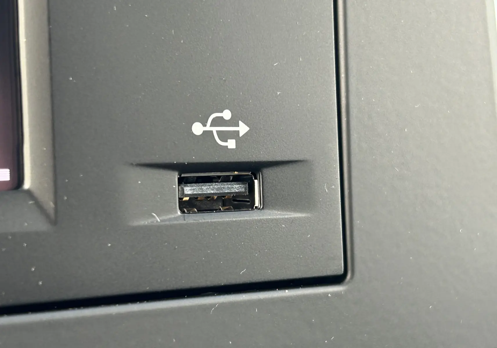 Gros plan sur un port USB intégré au tableau de bord noir du DANGEL Peugeot Partner 4x4 gris Artense.