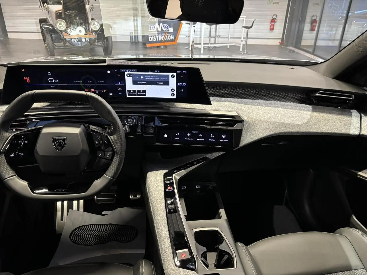 Vue intérieure avant du Peugeot 3008 gris Artense, mettant en valeur le tableau de bord numérique et la console centrale moderne.