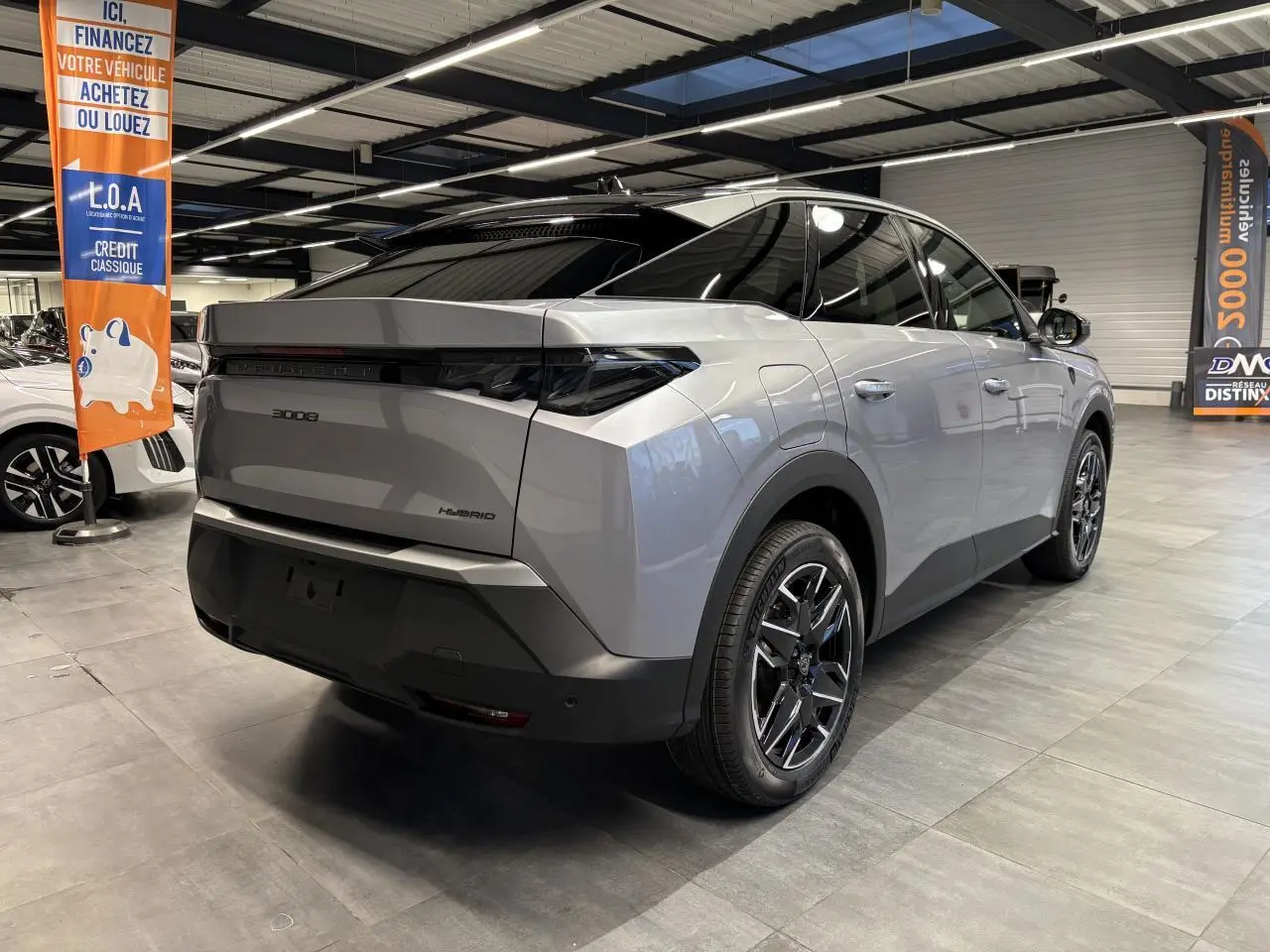 Vue 3/4 arrière droite du Peugeot 3008 Hybrid gris Artense avec feux arrière à griffes LED et jantes alliage 19 pouces.