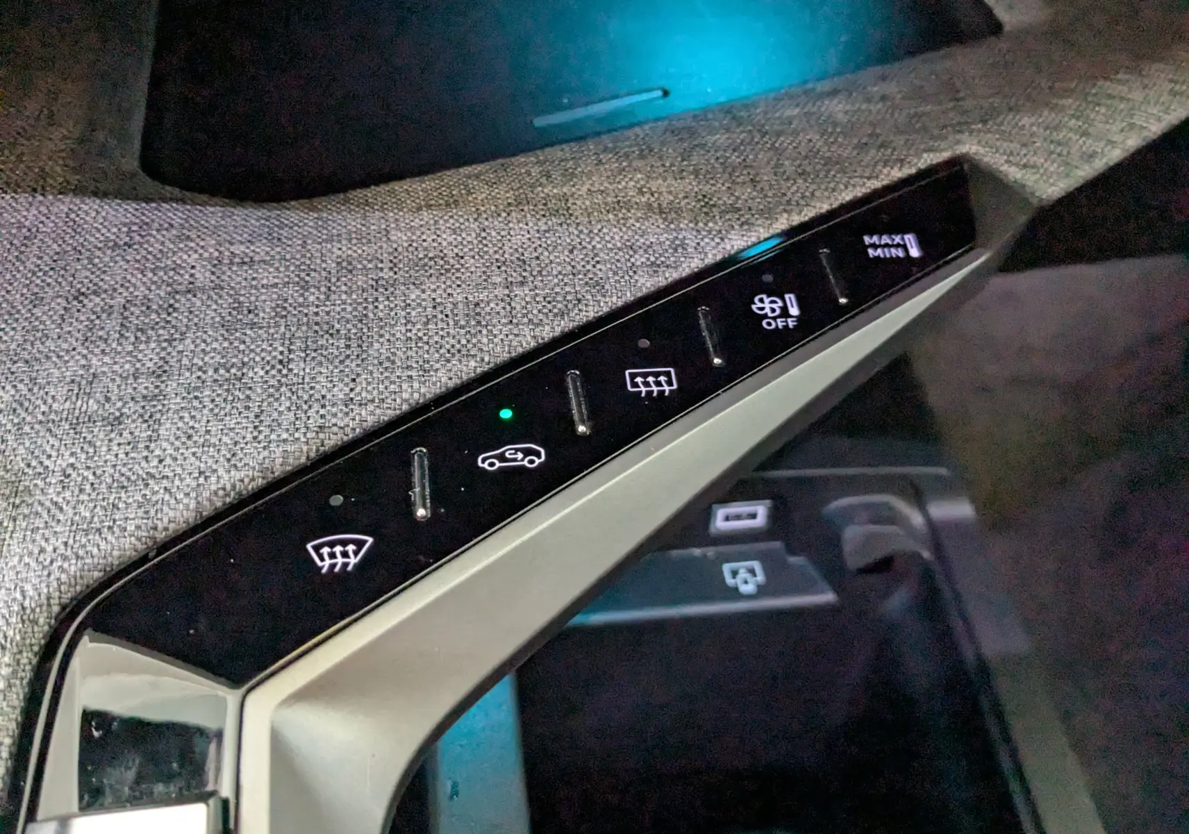 Gros plan sur la console centrale du Peugeot 3008 gris 2024, montrant les commandes tactiles de climatisation et ventilation.