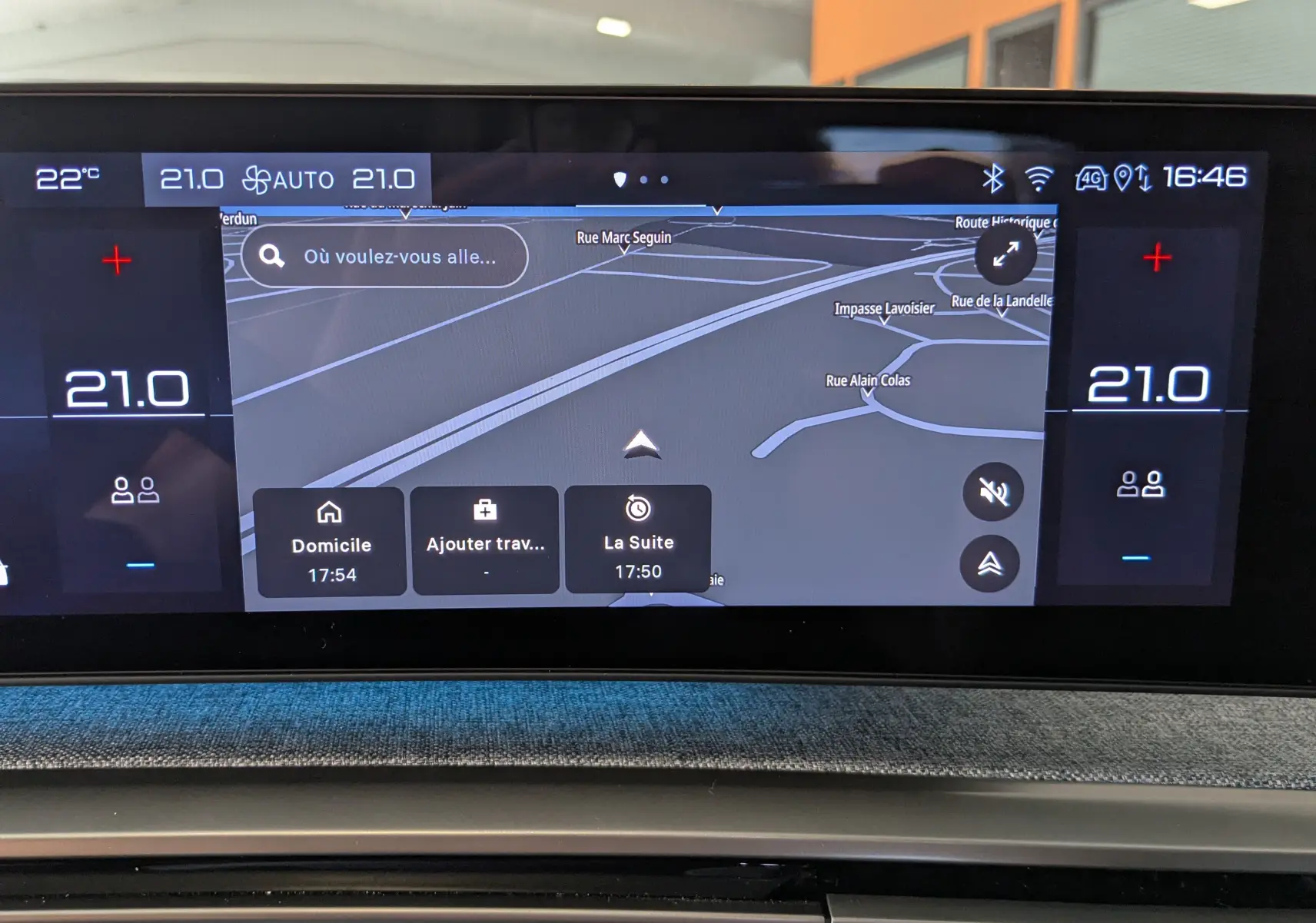 Écran tactile central du tableau de bord du Peugeot 3008 gris, affichant la navigation GPS et la climatisation à 21°C.