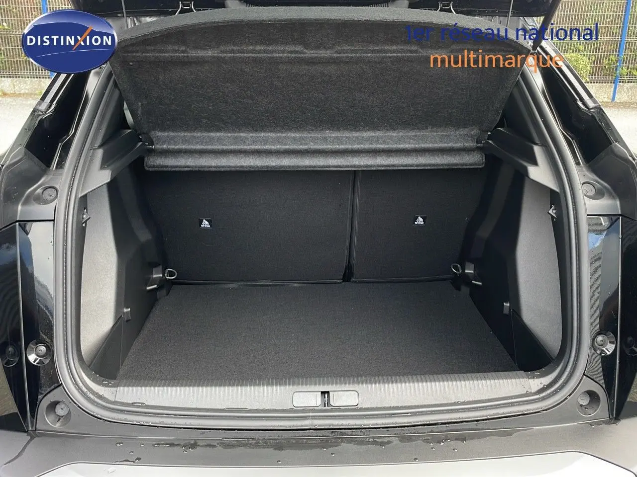 Coffre ouvert d'une Peugeot 2008 noir perla metal, vue arrière montrant l'espace de chargement vide.