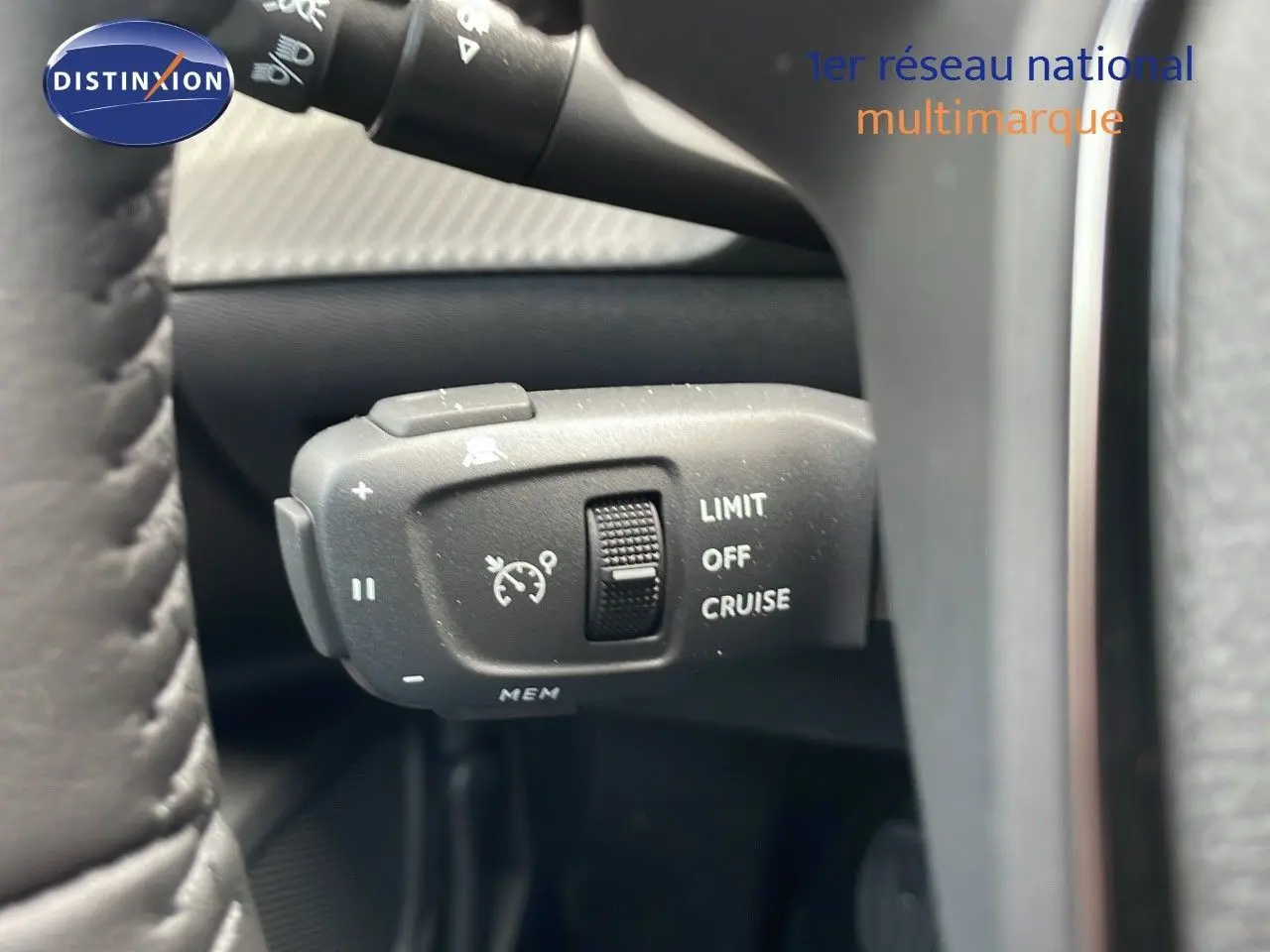 Gros plan sur la commande de régulateur de vitesse du Peugeot 2008 noir Perla Metal, côté gauche du volant.