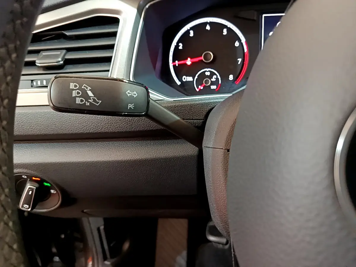 Gros plan sur la manette de clignotants et le tableau de bord noir du Volkswagen T-Roc 1.0 TSI 110 LOUNGE BUSINESS.