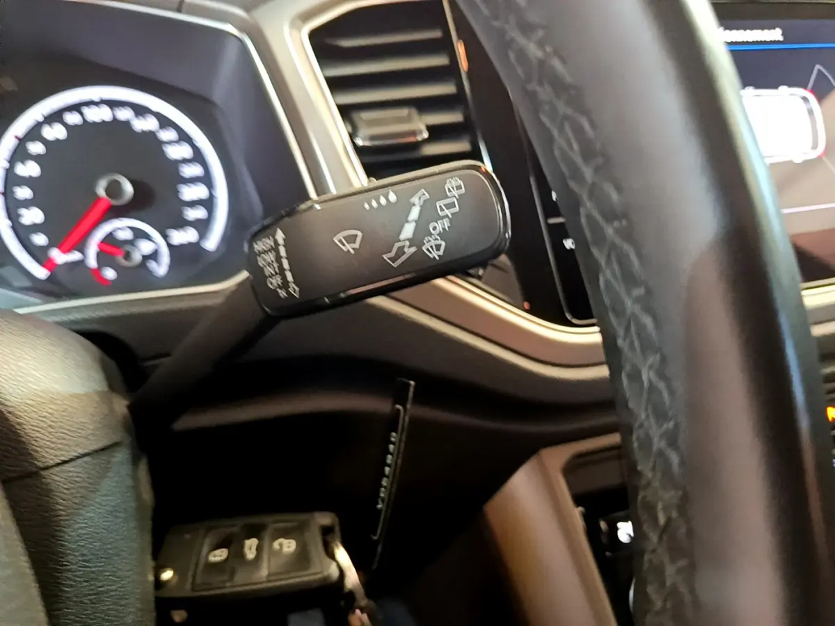 Gros plan sur la manette d'essuie-glace côté gauche du tableau de bord d'un Volkswagen T-Roc 2021 gris foncé.