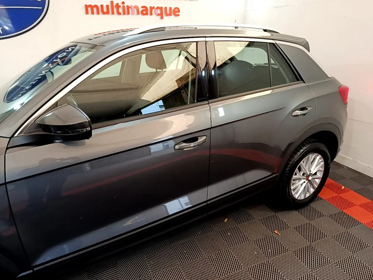 Profil côté gauche du Volkswagen T-Roc gris foncé 2021, mettant en valeur la carrosserie lisse et les jantes alliage.