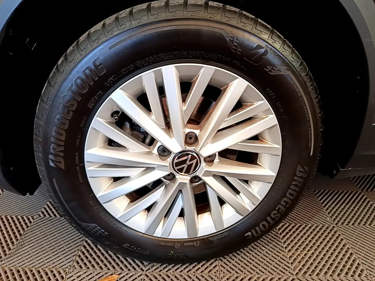 Gros plan sur la jante alliage argentée et pneu Bridgestone du Volkswagen T-Roc gris foncé, côté gauche.